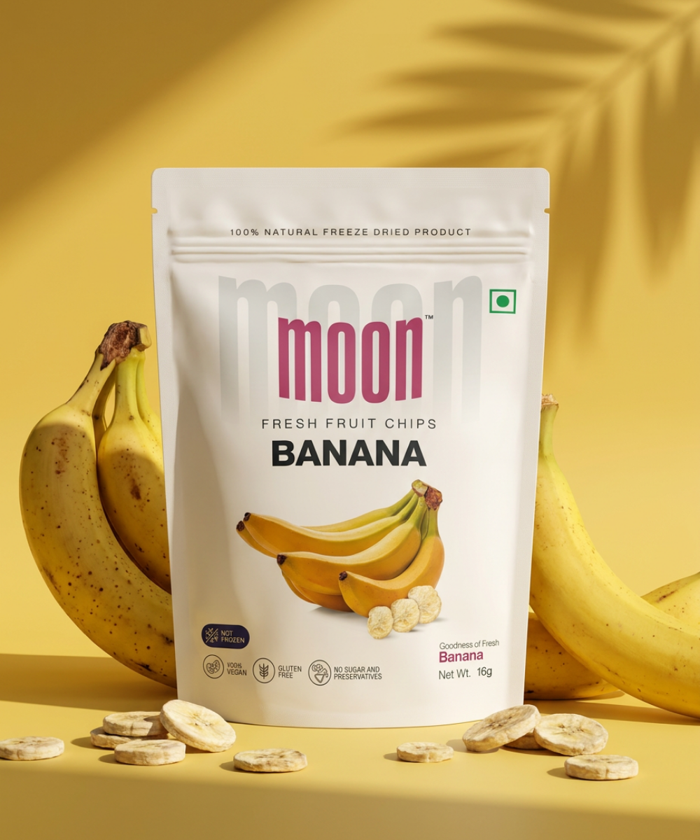 A pack of Themoonstoreindia Moon Freeze Dried Banana, a gluten-free healthy snack, is shown in front of whole bananas and banana slices on a yellow background.