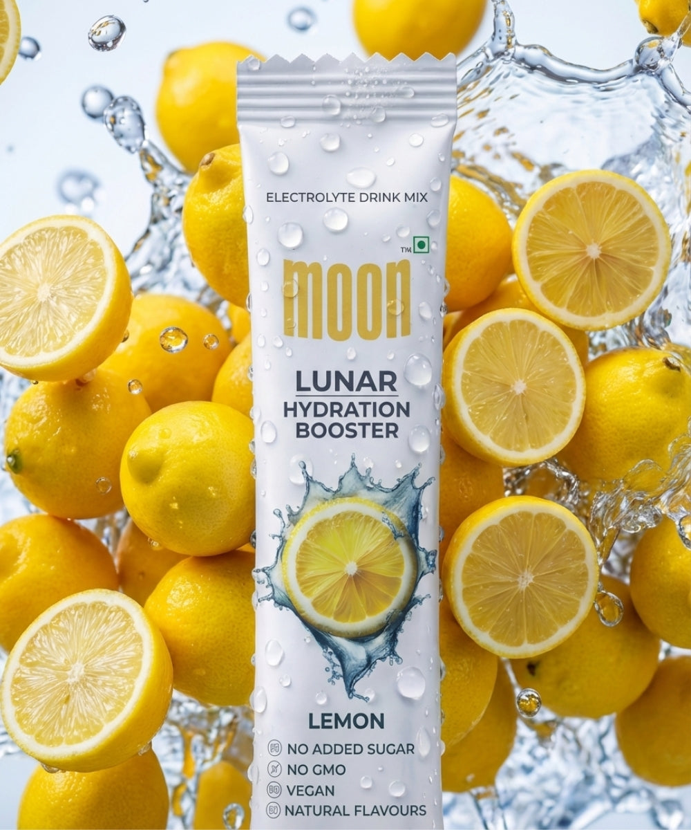 A packet of MOONFREEZE FOODS' Lunar Hydration Booster - Lemon Flavour, a no sugar added electrolytes drink with natural flavors, non-GMO and veganβshown with fresh lemons and water splashes.