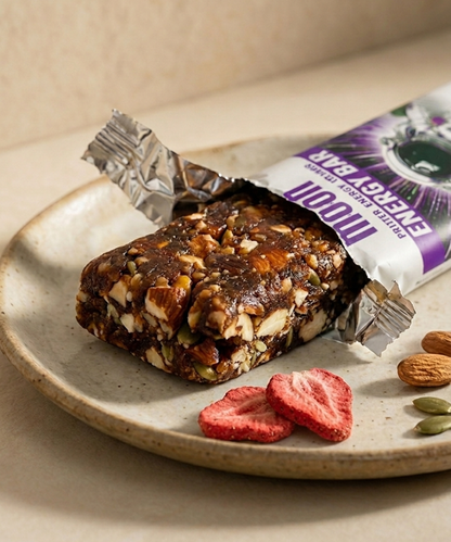 MOONFREEZE FOODS PRIVATE LIMITED’s MOON Energy Bar - Strawberry is served unwrapped on a plate with freeze-dried strawberries and almonds—a convenient meal replacement for busy days.